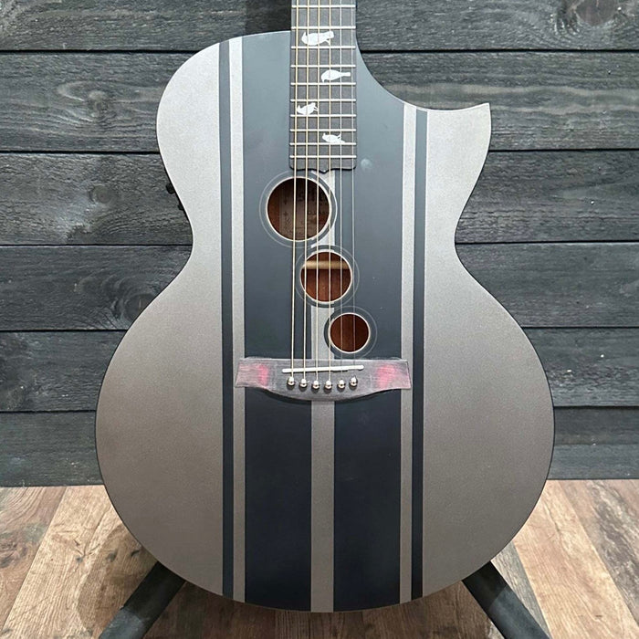 Acoustic guitar with black and silver design on a wooden background