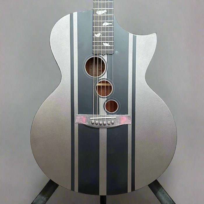 Acoustic guitar with black and silver design on a wooden background