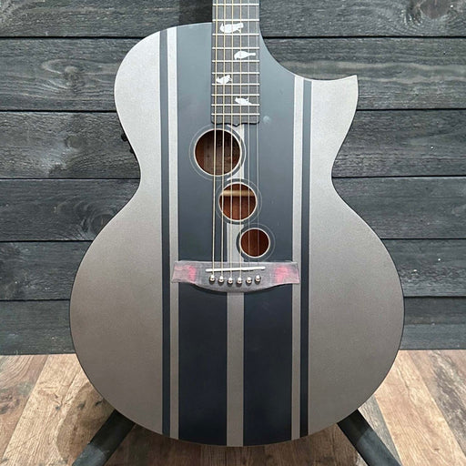 Acoustic guitar with black and silver design on a wooden background